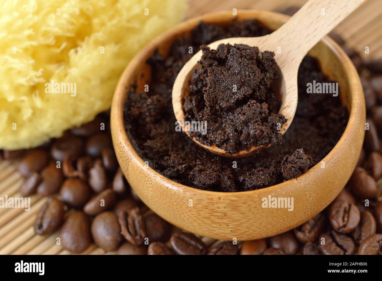 Masque pour gommage au café fait maison dans un bol en bois avec cuillère sur des grains de café Banque D'Images