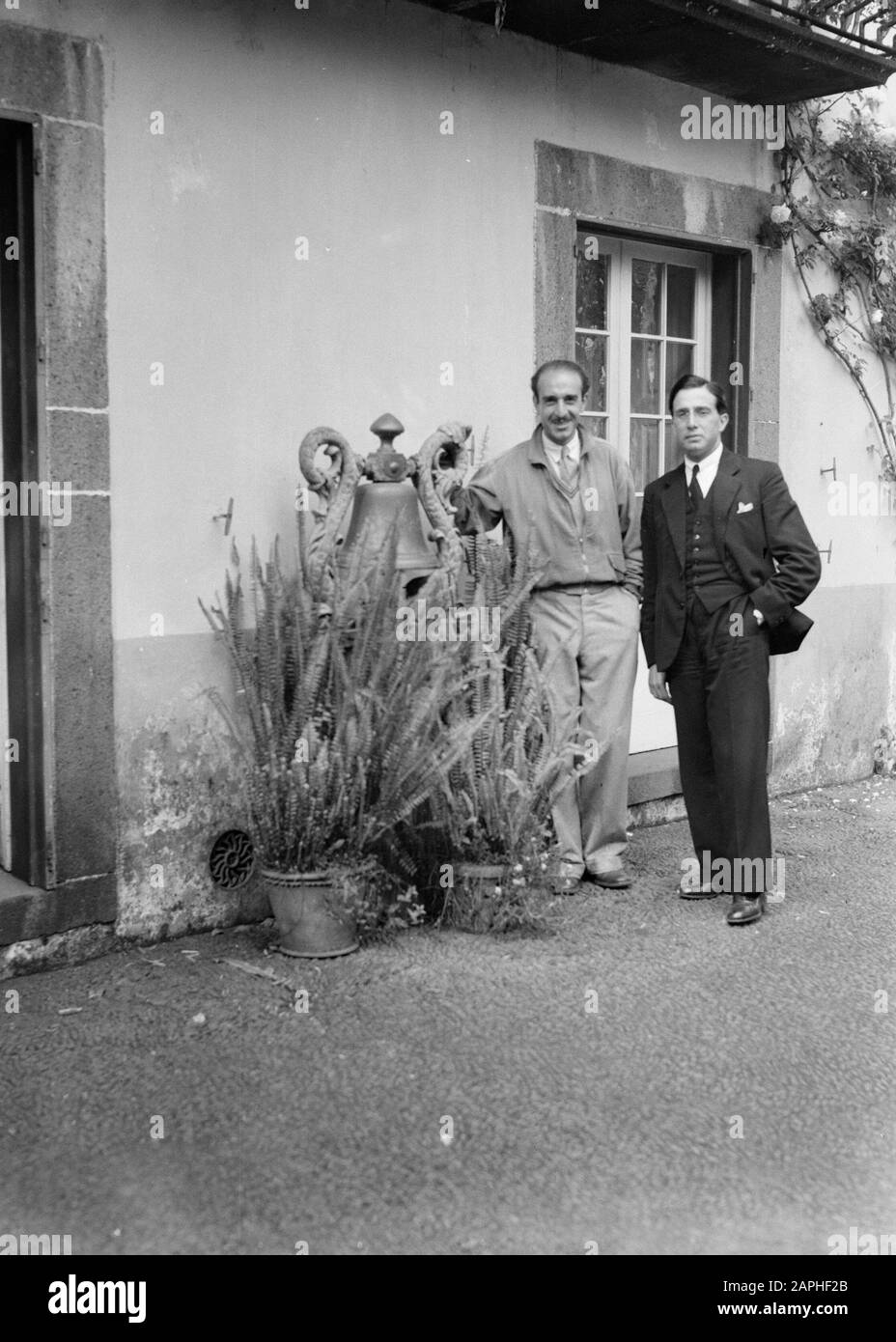 Madeira Description: Les hommes Bianchi et Lugiero Freitas Martins pour une maison à Madère à côté d'une horloge et des pots avec des plantes. Date: 1934 Lieu: Madère, Portugal Mots Clés: Plantes, Habitations Nom Personnel: Bianchi, [...], Lugiero Freitas Martins, [...] Banque D'Images