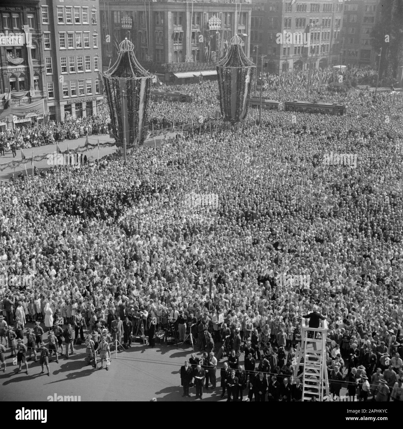 Cinquante ans de jubilé du gouvernement de la Reine Wilhelmina Description: La famille royale sur le palais balcon, à l'écoute d'une aubade sur de Dam par 19000 chanteurs, chanteurs et écoliers. Au premier plan, le chef d'orchestre de 80 ans Fred.J. Roeske. Date: 31 août 1948 lieu: Amsterdam, Noord-Holland mots clés: Chefs d'orchestre, photographes, anniversaires, maison royale, chorales, scouts, carrés Nom personnel: Roeske, F.J. Banque D'Images