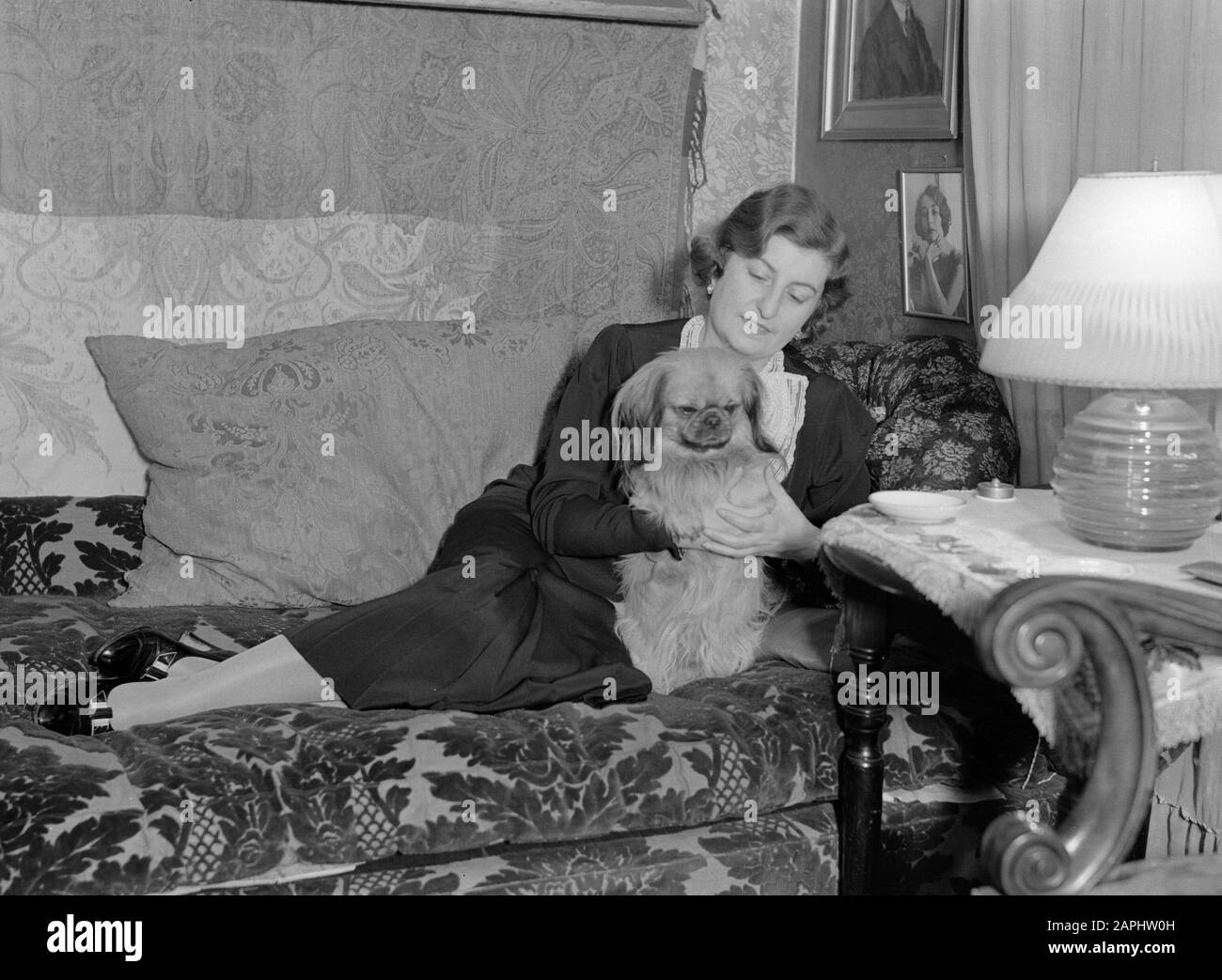 Voyage en Pologne Description: La soprano polonaise Ewa Bandrowska-Turska avec son chien sur un divan Annotation: Ewa Bandrowska-Turska (1894-1979) était une chanteuse d'opéra célèbre qui n'était pas seulement en Pologne mais aussi en Europe occidentale et aux États-Unis a agi. En 1946, elle devient chargée de cours au Conservatoire de Cracovie et plus tard au Conservatoire de Varsovie. Elle a reçu le Prix d'Etat de la République Populaire polonaise en 1952 Date: 1934 lieu: Pologne, Varsovie mots clés: Opéras, portraits, chanteurs Nom personnel: Bandrowska-Turska, Ewa Banque D'Images