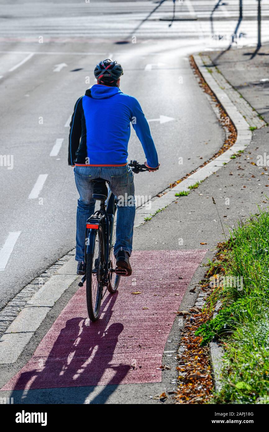 Cycliste passant de la trajectoire de cycle à une route de cyclisme et un sentier de randonnée combinés Banque D'Images