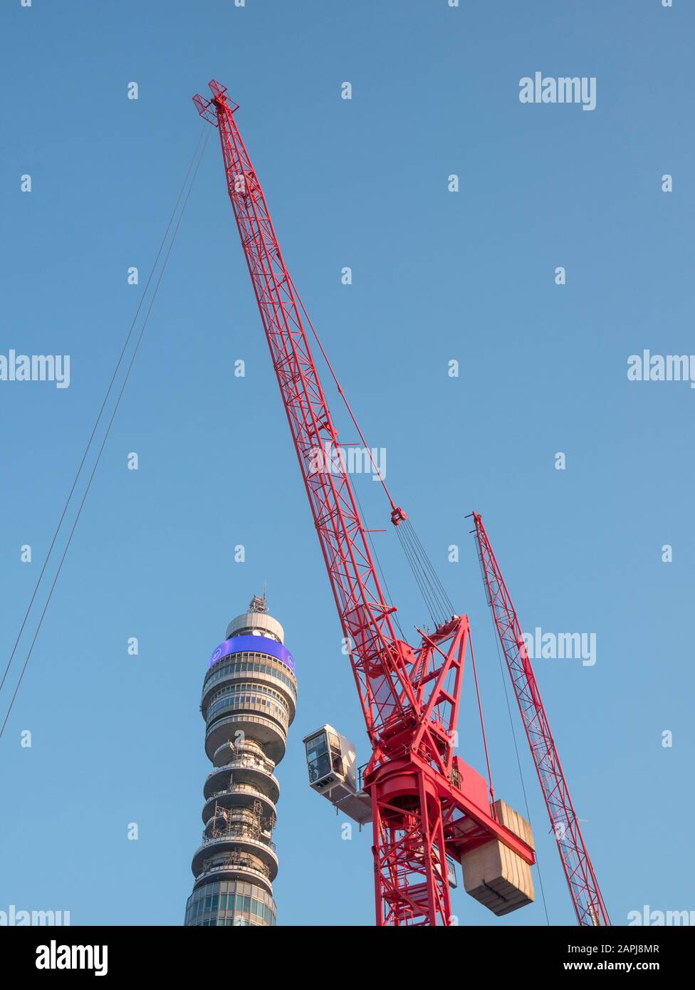 Grue de tour rouge et tour de poste contre le ciel bleu au soleil de printemps. Métaphore activité de construction de Londres, nouvelles constructions, visite de Londres. Banque D'Images