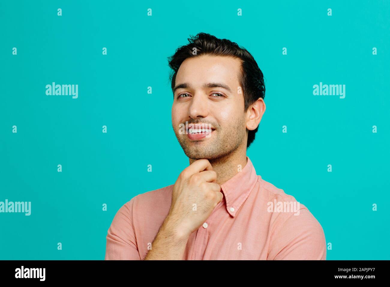 Portrait d'un jeune homme adulte souriant, isolé sur fond bleu de studio Banque D'Images