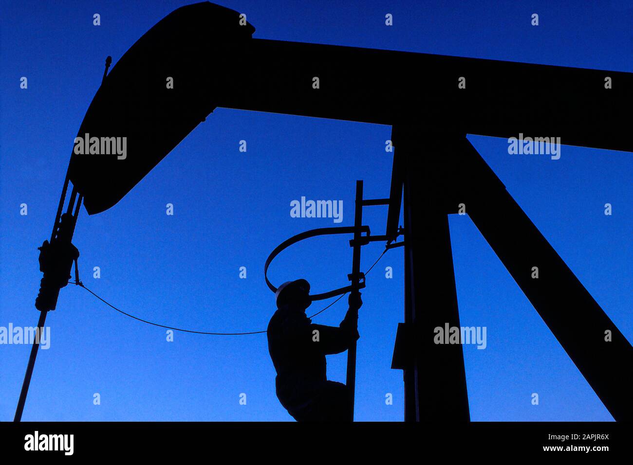 Technicien en pétrole et en gaz effectuant un entretien sur un cric rouleur Banque D'Images