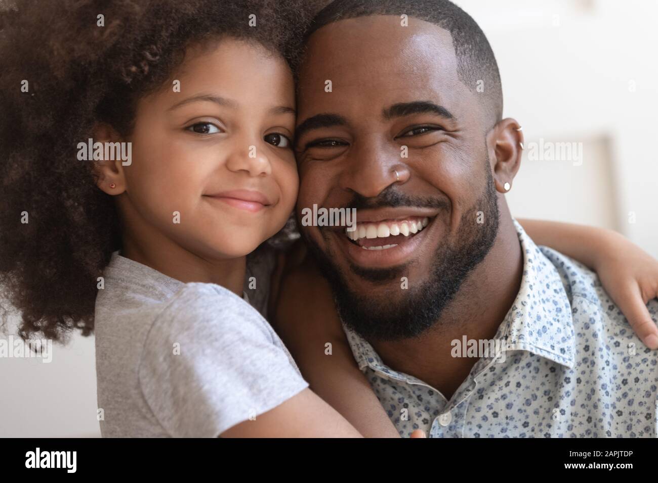 Gros plan visages portrait la fille africaine embrasse le père Banque D'Images