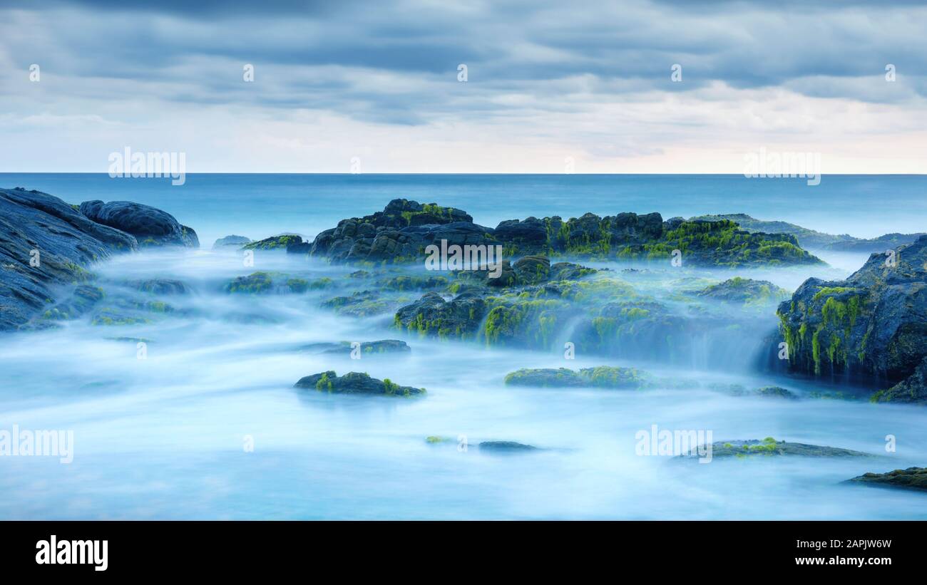 Longue exposition de l'océan mystère et des roches. Paysage tropical avec des pierres surréalistes sur la plage de la mer. Vue panoramique sur l'eau comme le brouillard et la brume. Beau panor Banque D'Images