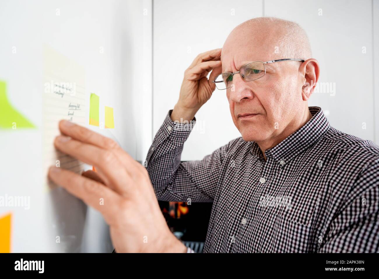 Un homme âgé à la recherche de notes. Oublieux des hauts avec la démence, problème de mémoire, concept de santé Banque D'Images