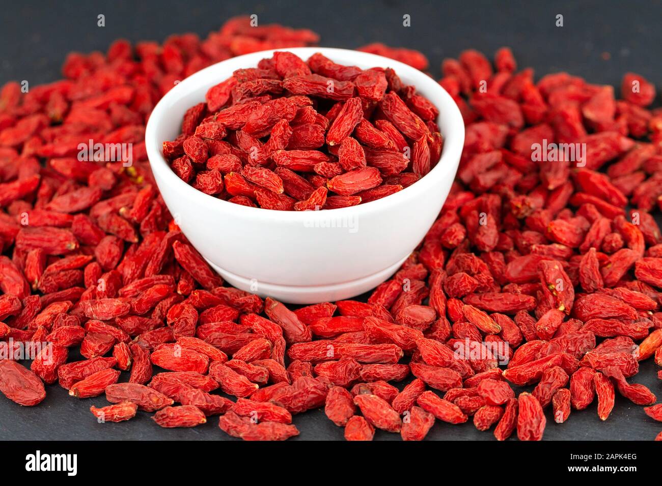 Gros plan de baies de goji dans une tasse blanche. Mise au point sélective Banque D'Images