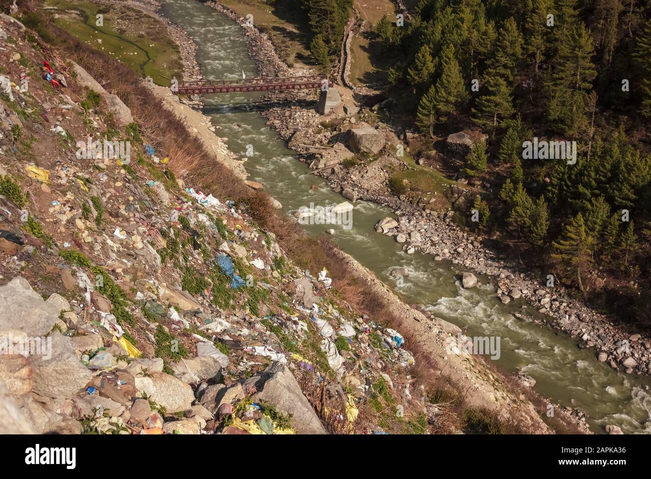 Une pente raide qui descend vers la rivière Baspa jonchée de déchets en plastique jetés par les touristes dans le village de Chitkul dans l'Himachal Pradesh, en Inde. Banque D'Images