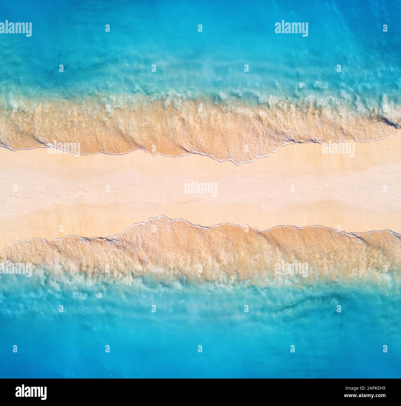 Vue aérienne sur la mer bleue avec des vagues sur les deux côtés au coucher du soleil Banque D'Images