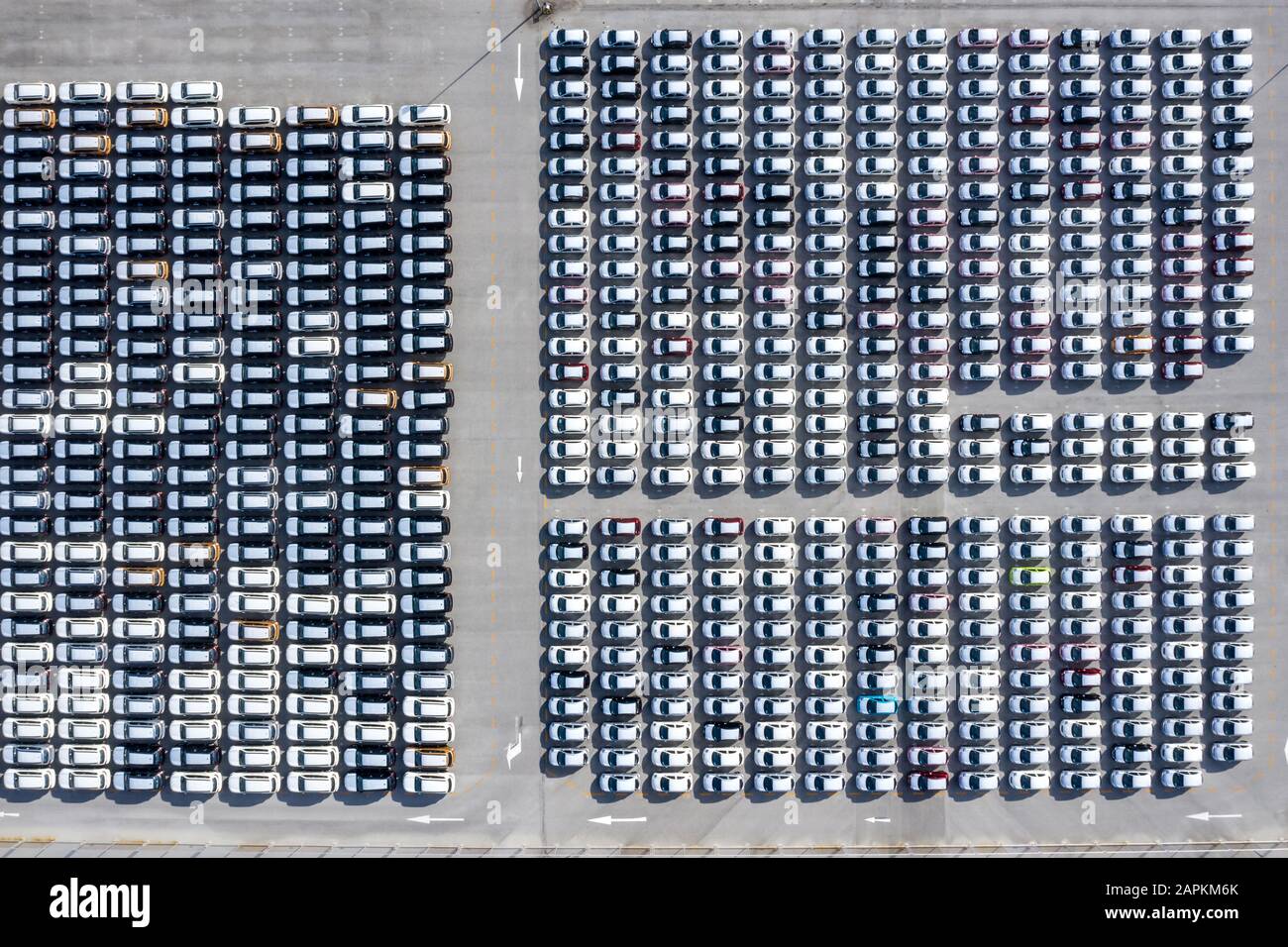 Vue aérienne de dessus de nouvelles voitures alignées dans le port pour l'importation de logistique d'affaires d'exportation et de transport par navire dans la mer ouverte. Nouvelle voiture de l'usine Banque D'Images