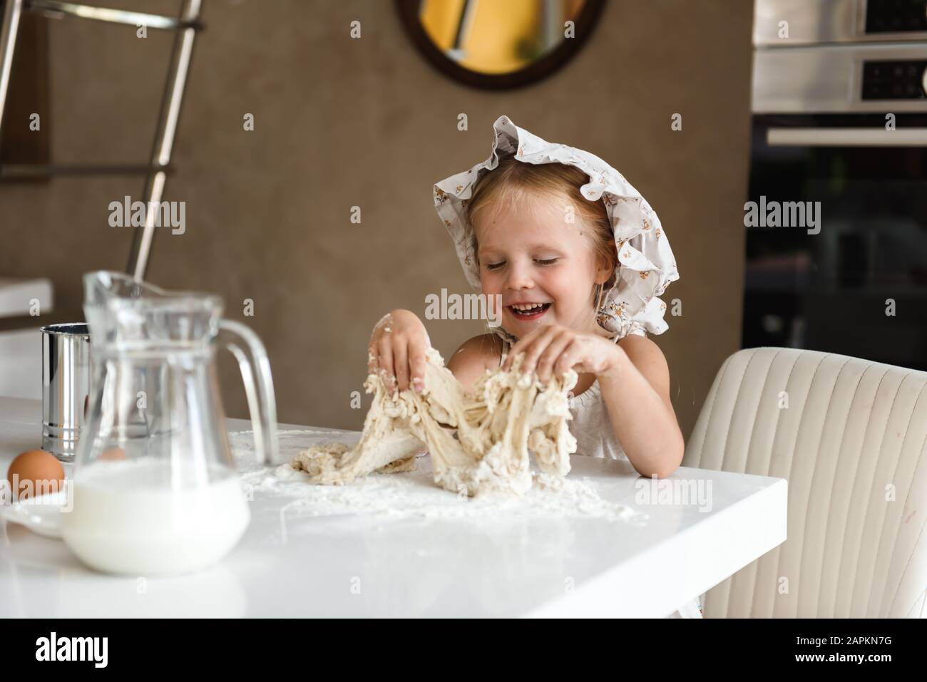 Une petite fille cuisant de la pizza dans la cuisine Banque D'Images