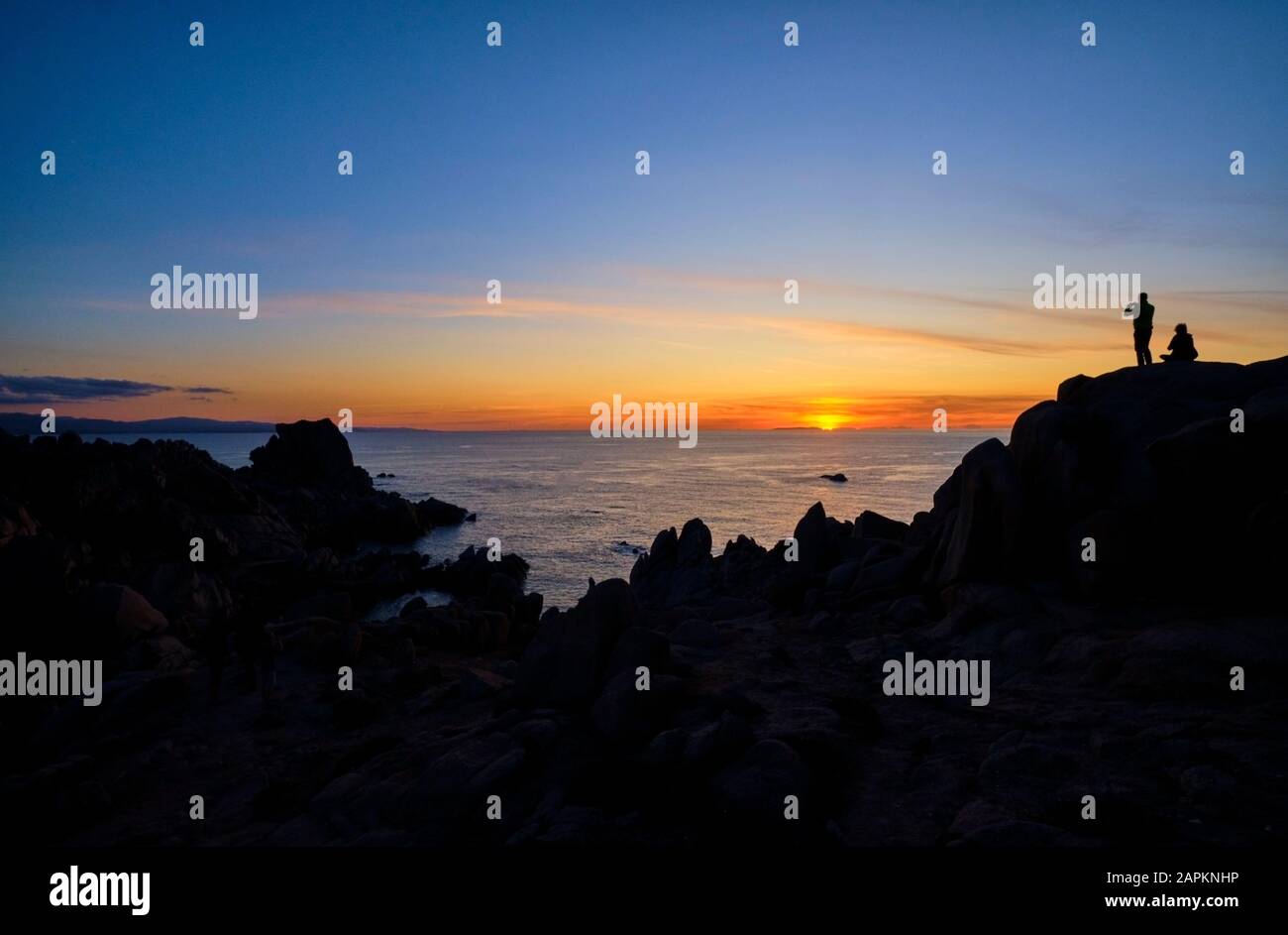 Italie, Province de Sassari, Santa Teresa Gallura, Silhouette de couple admirant le coucher de soleil sur la mer Méditerranée depuis le haut du Cap Testa Banque D'Images