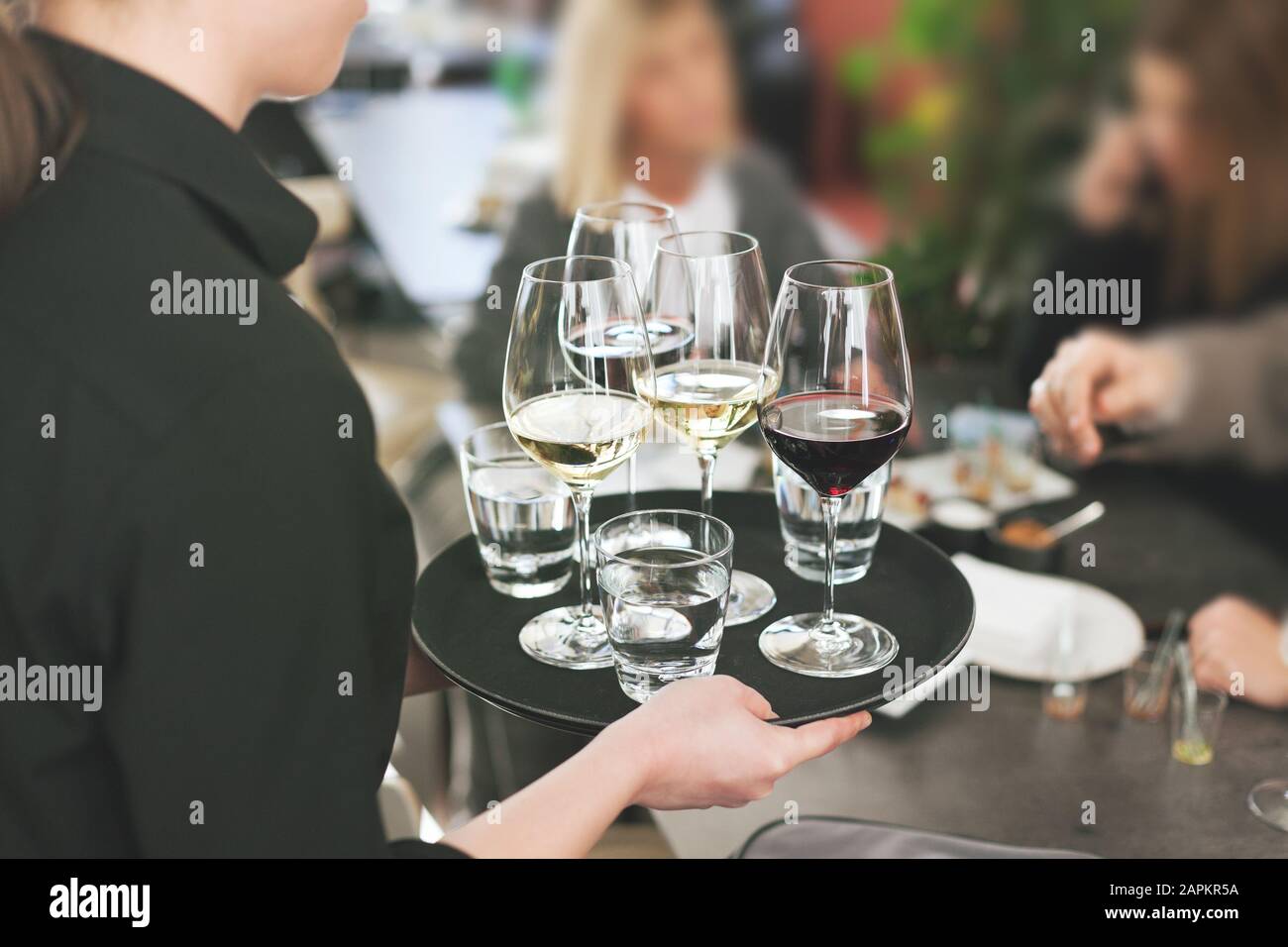 serveuse au restaurant servant du vin blanc et rouge à table pleine de personnes Banque D'Images serveuse au restaurant servant du vin blanc et rouge à table pleine de personnes Banque D'Images