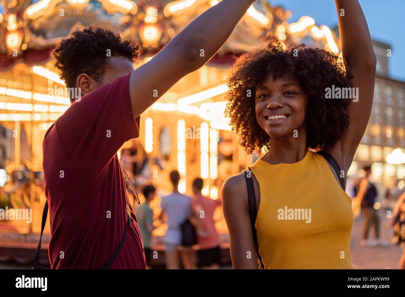 Jeune couple touristique dans un carrousel éclairé dans la ville au crépuscule, Florence, Italie Banque D'Images