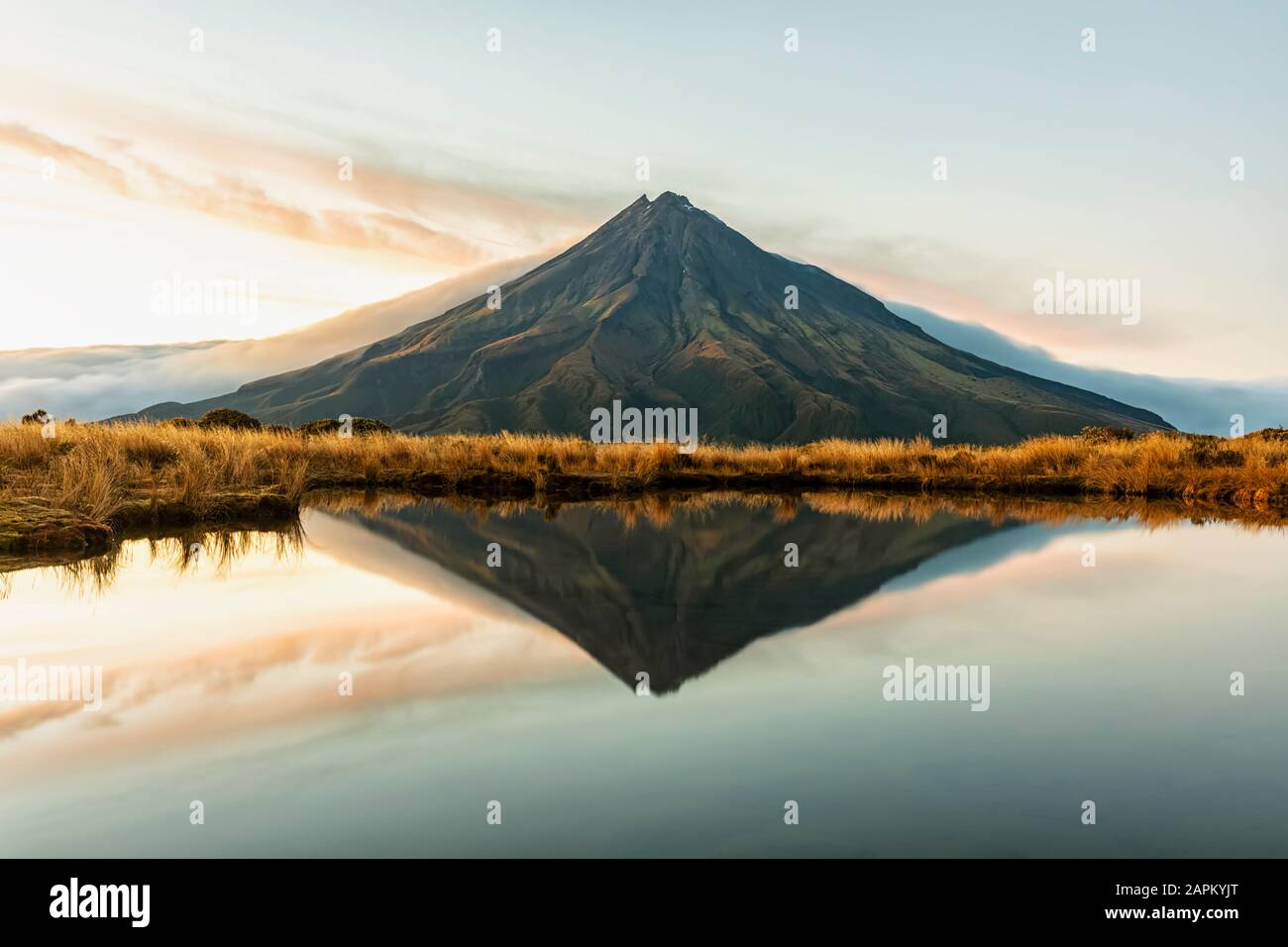 Nouvelle-Zélande, volcan du Mont Taranaki réfléchissant dans un lac brillant à l'aube Banque D'Images