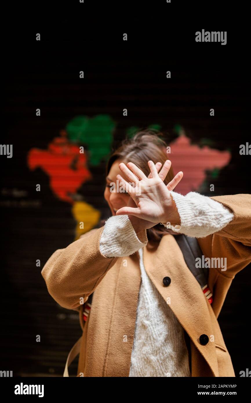 Heureuse jeune femme couvrant son visage avec ses mains Banque D'Images