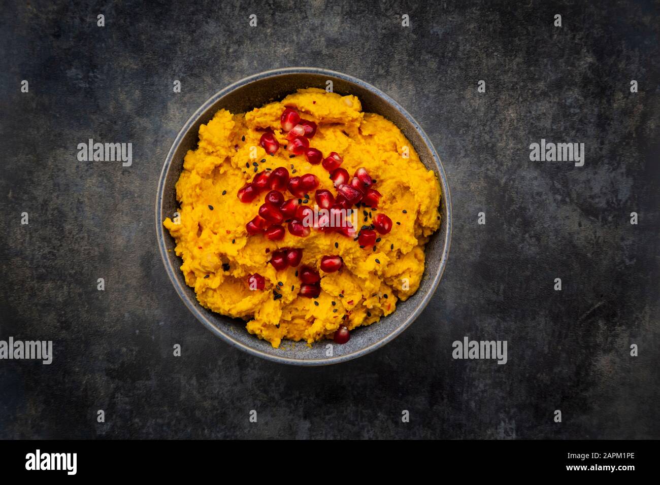 Bol de houmous de citrouille avec graines de sésame noir et de grenade Banque D'Images