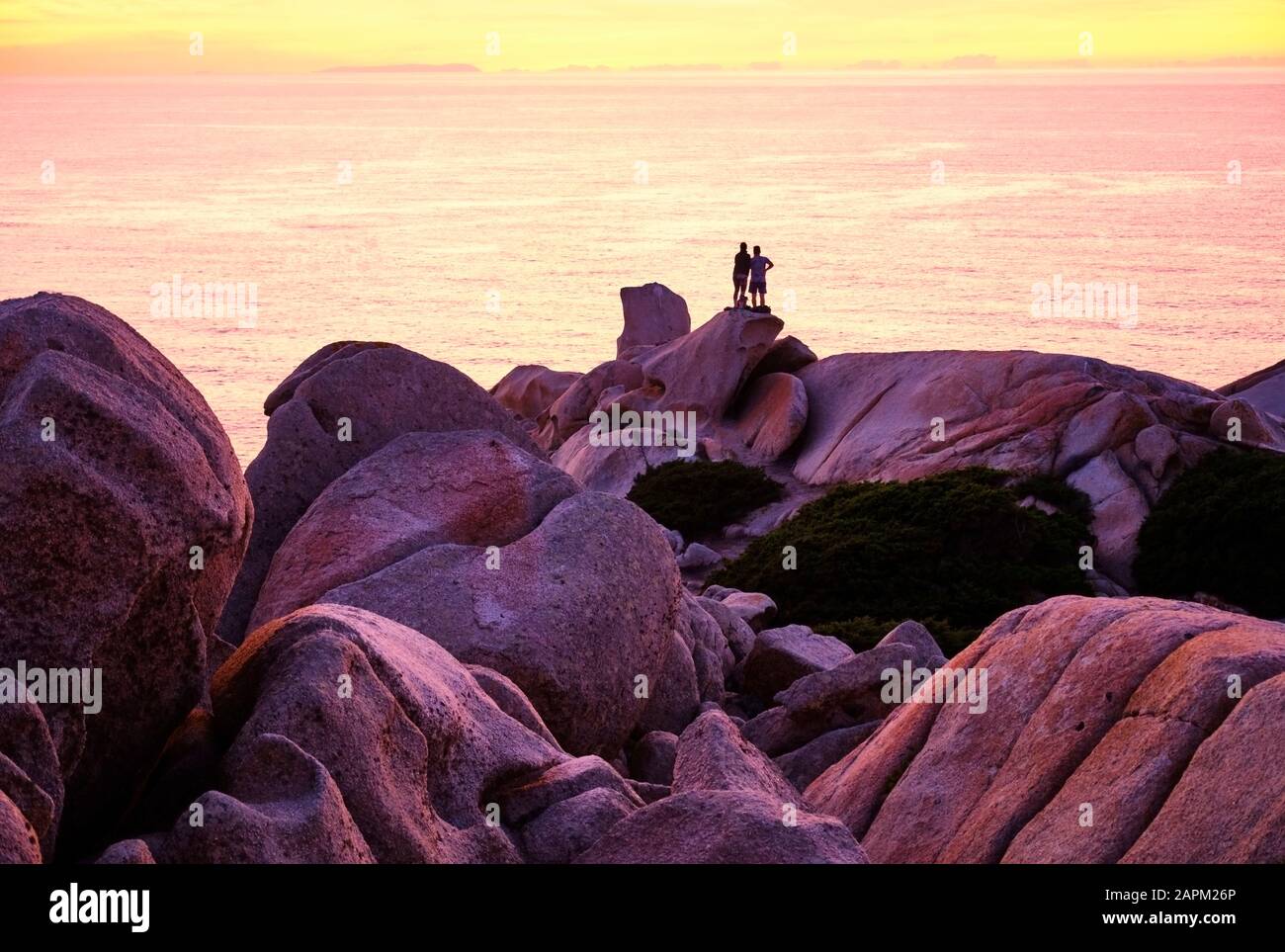 Italie, Province de Sassari, Santa Teresa Gallura, Silhouette de couple admirant le coucher de soleil sur la mer Méditerranée depuis le haut du Cap Testa Banque D'Images