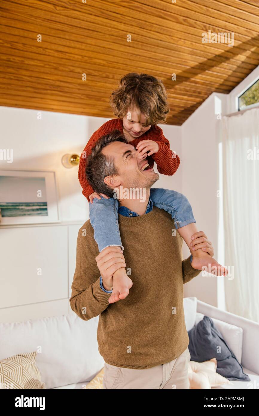 Joyeux père portant sa fille sur les épaules à la maison Banque D'Images