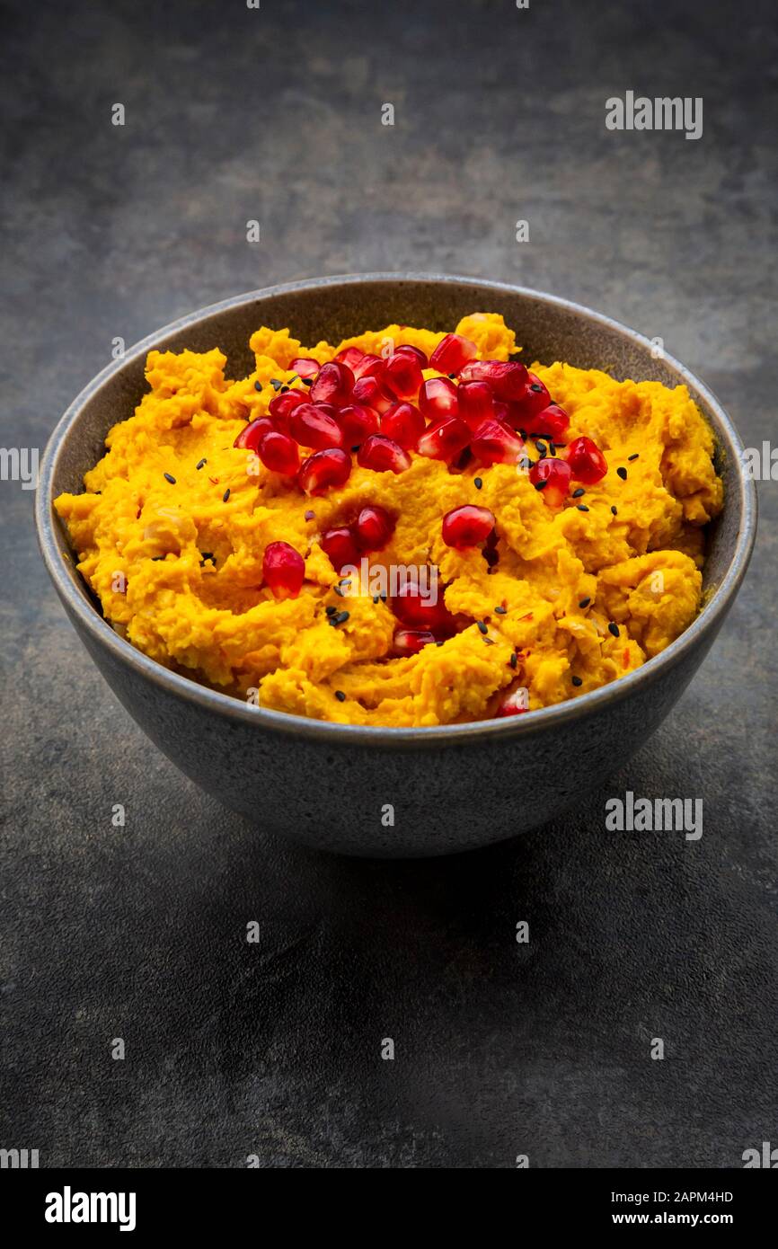 Bol de houmous de citrouille avec graines de sésame noir et de grenade Banque D'Images