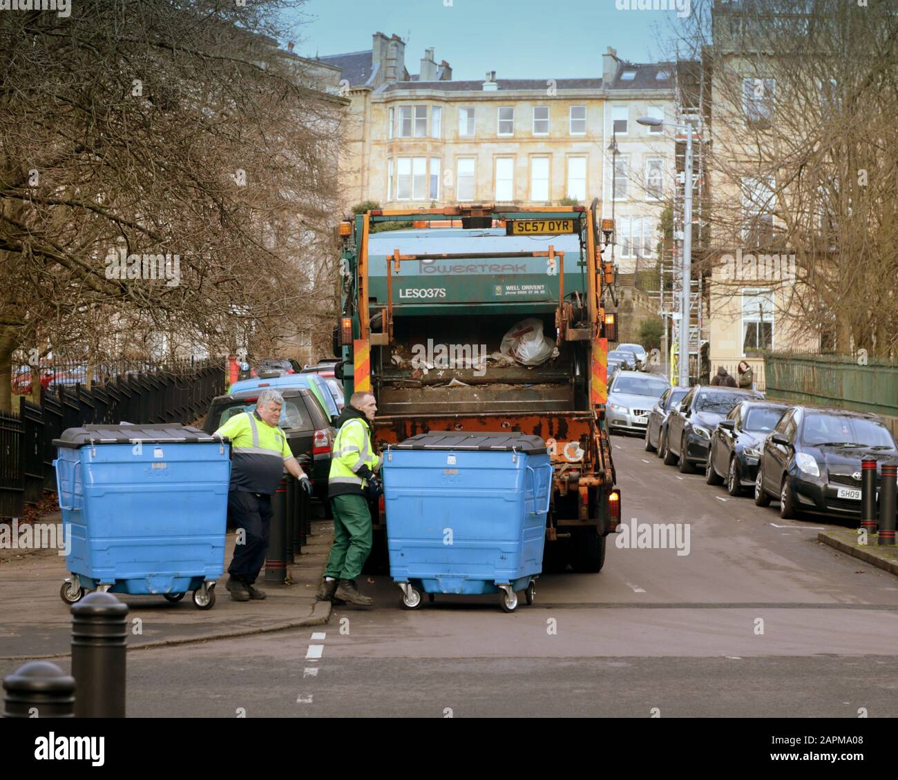 bennes hommes à l'arrière d'un camion à ordures dans le parc de cirque kelvingrove aire de parc chargement des poubelles ou des bennes à roues Banque D'Images