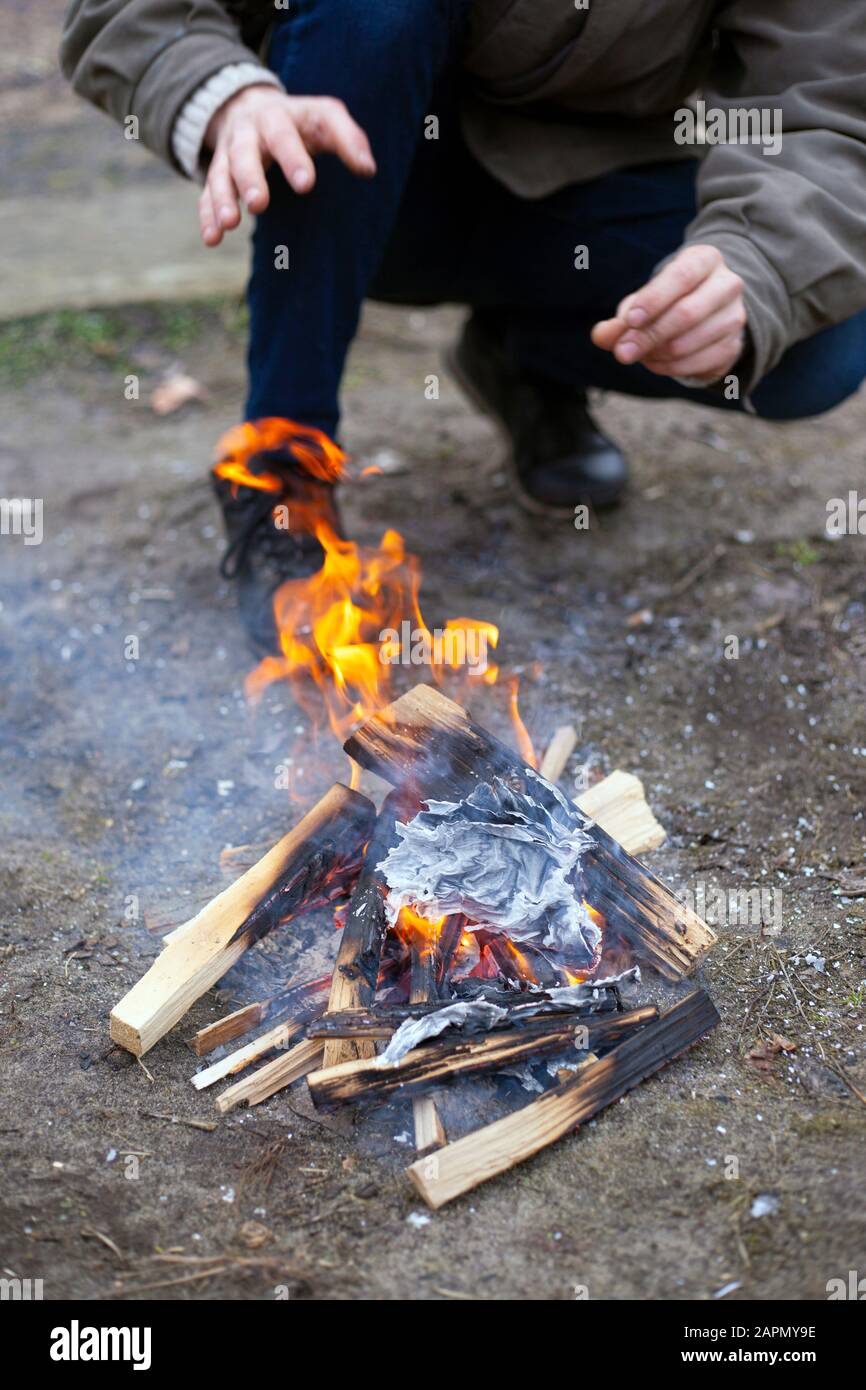 chauffez vos mains par le feu. le gars essaie de se débarrasser du froid avec la flamme. Banque D'Images