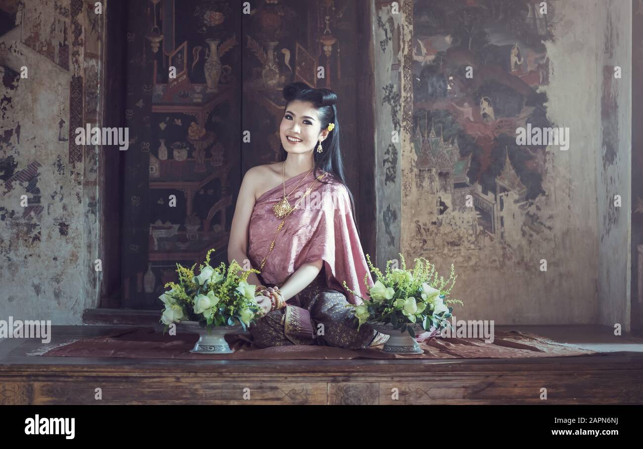 Asian woman wearing costume traditionnel Thaï hand holding fleur de lotus Banque D'Images