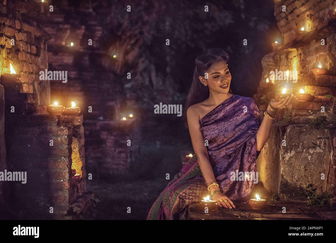 Belle fille thaïlandaise en costume traditionnel thaïlandais avec bougie la nuit Banque D'Images