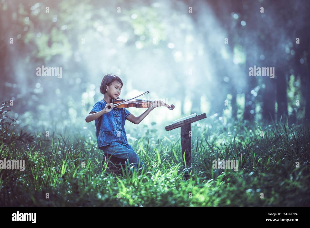 La comédie musicale : petit enfant asiatique jouant au violon à l'extérieur Banque D'Images