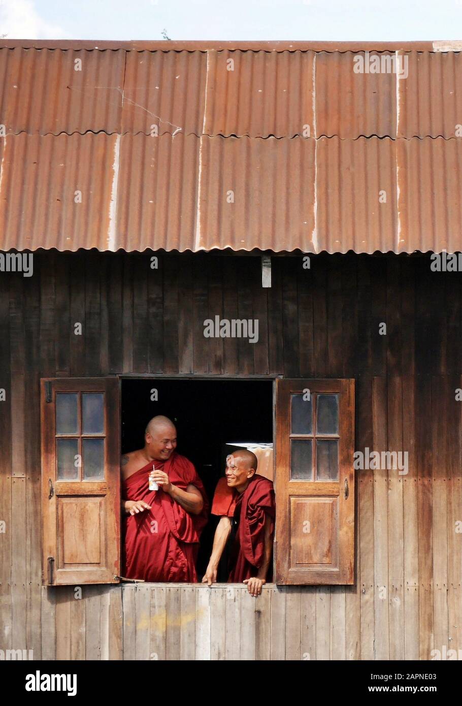 Deux moines bouddhistes discutant à la fenêtre tout en regardant le festival Phaung Daw Oo, Inle Lake, Myanmar (Birmanie) Banque D'Images