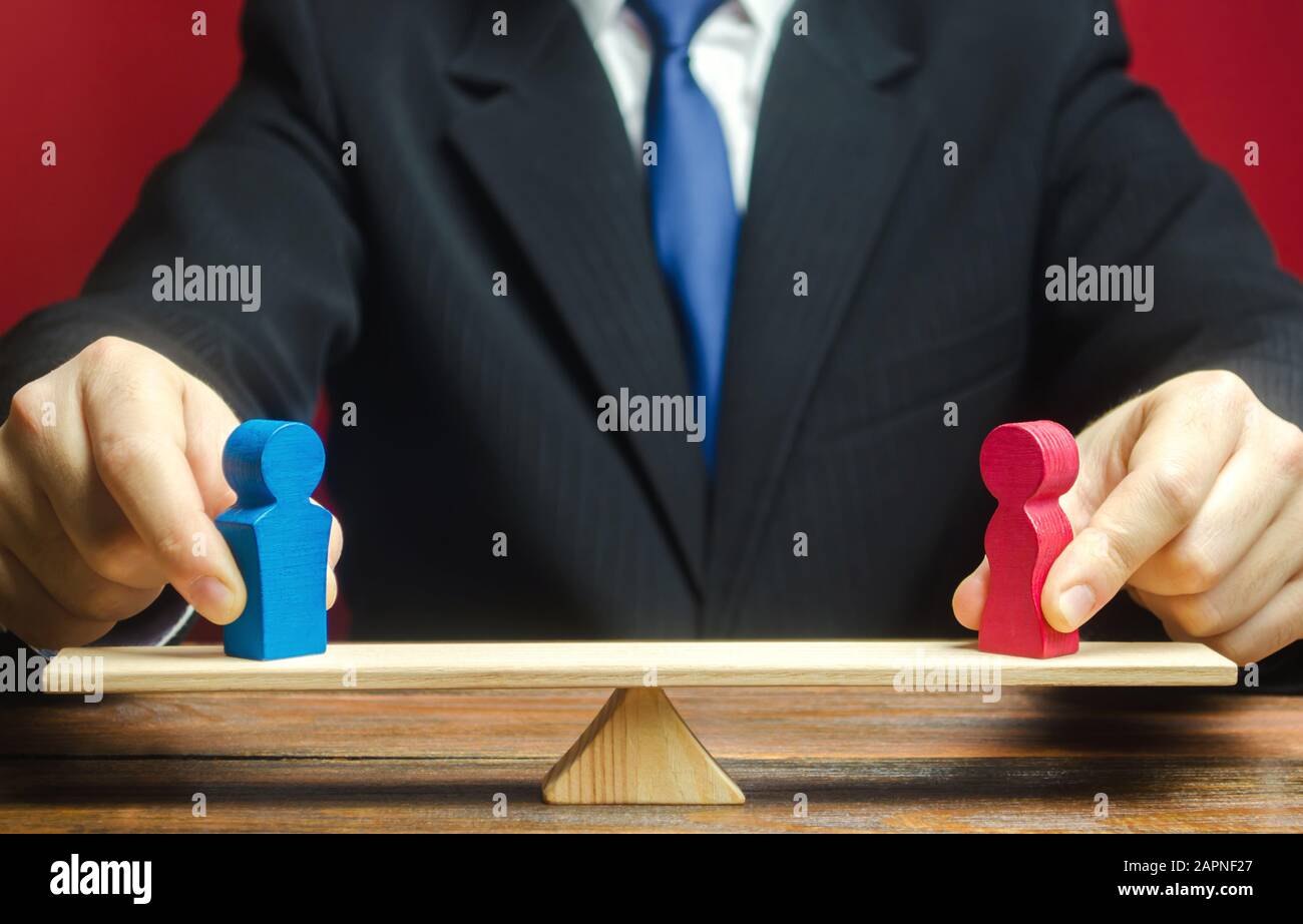 La figure d'un homme et une femme sur les balances. Écart de rémunération entre les sexes. L'égalité, l'inégalité. La notion de divorce et de partage des biens. La résolution de famille dis Banque D'Images