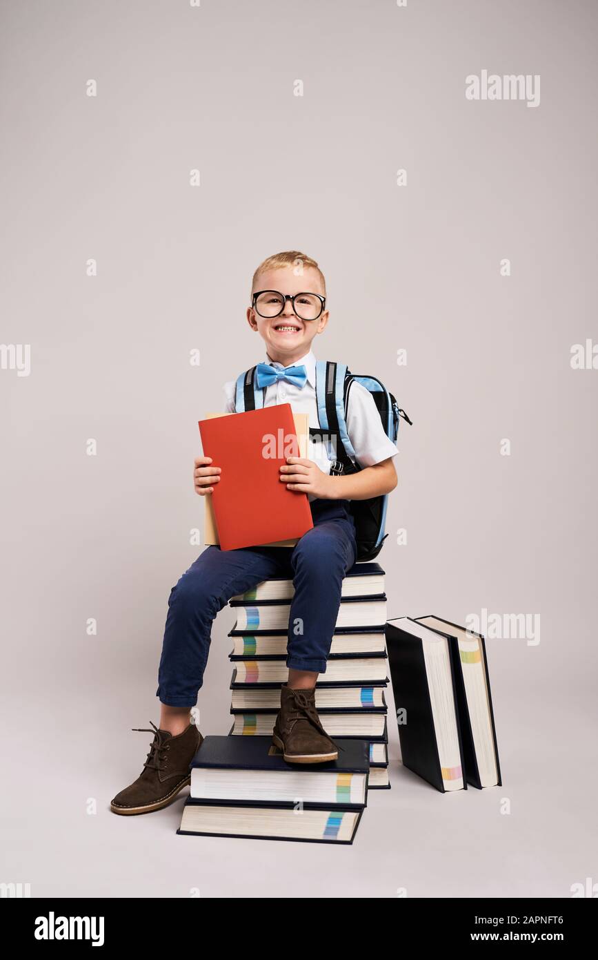 Portrait d'un enfant souriant parmi une pile de livres Banque D'Images