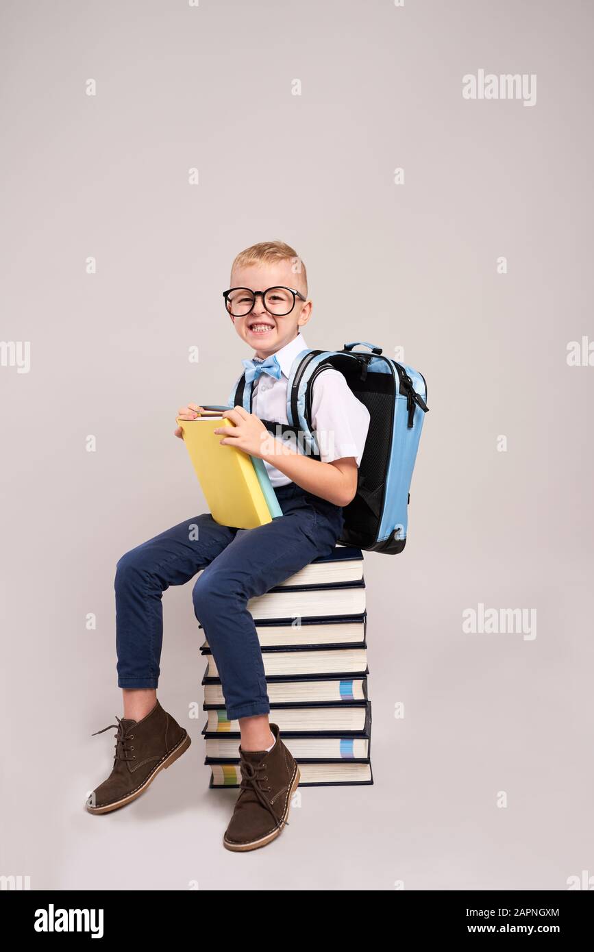 Enfant heureux avec sac à dos et pile de livres Banque D'Images