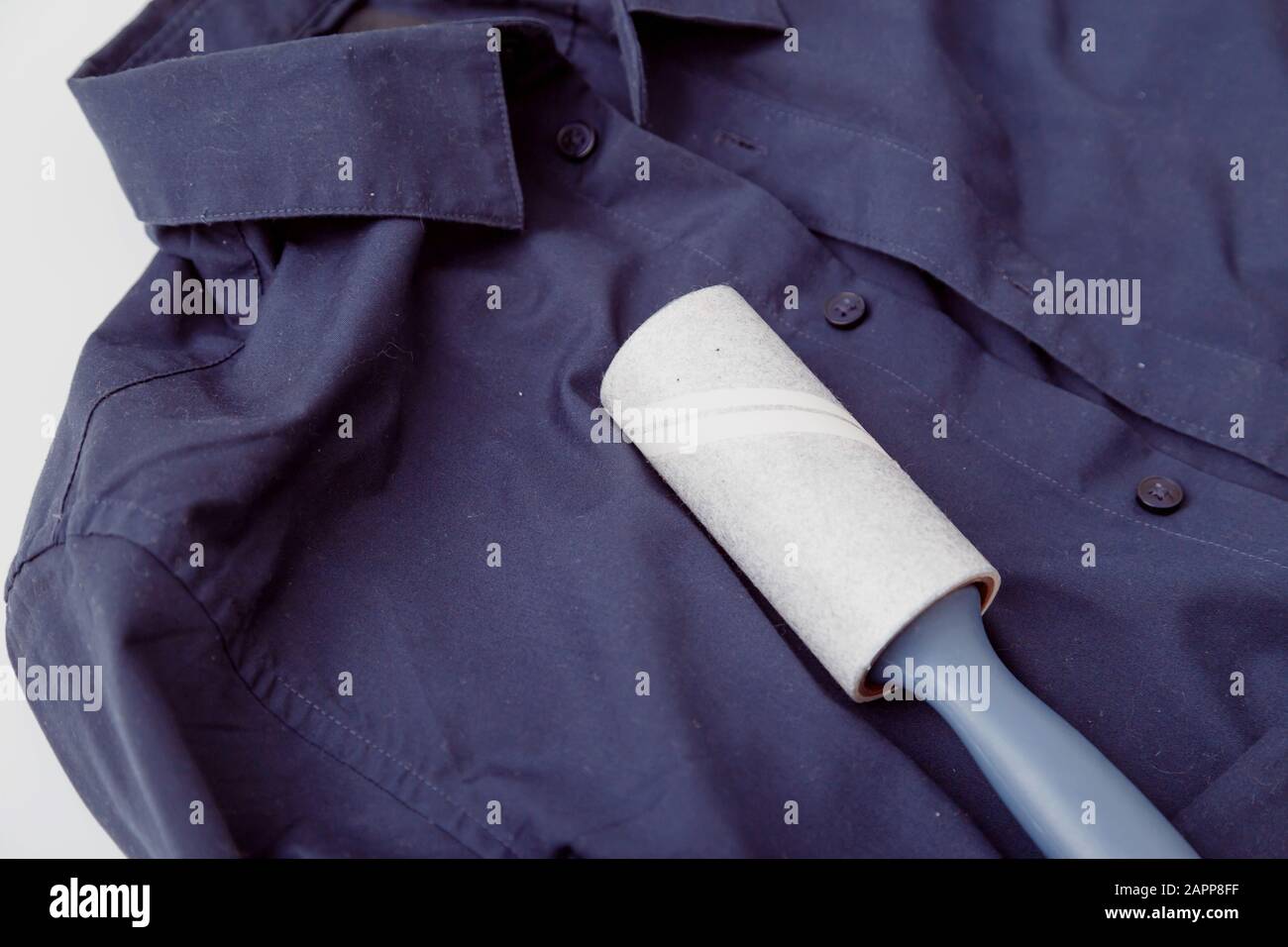 Chemise de couleur sombre avec colle statique, recouverte de poussière, de  peluches, de peluches et de poils et de rouleaux collants pour nettoyer les  vêtements Photo Stock - Alamy