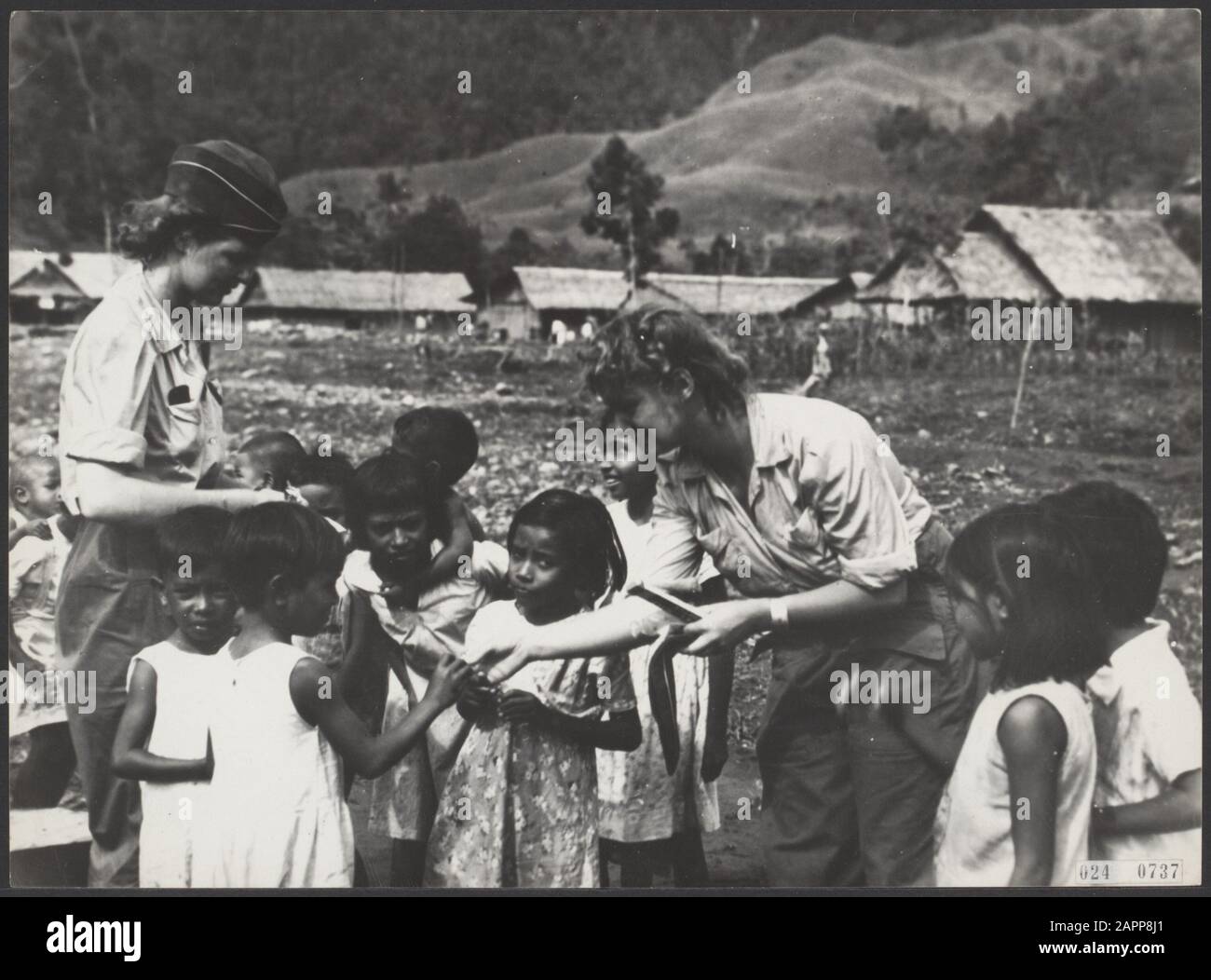 Les infirmières néerlandaises arrivant d'Australie font de l'amitié avec les enfants autochtones de Conica en Nouvelle-Guinée Date: Juillet 1945 lieu: Nouvelle Guinée mots clés: Assistance, enfants, seconde Guerre mondiale, infirmières Banque D'Images