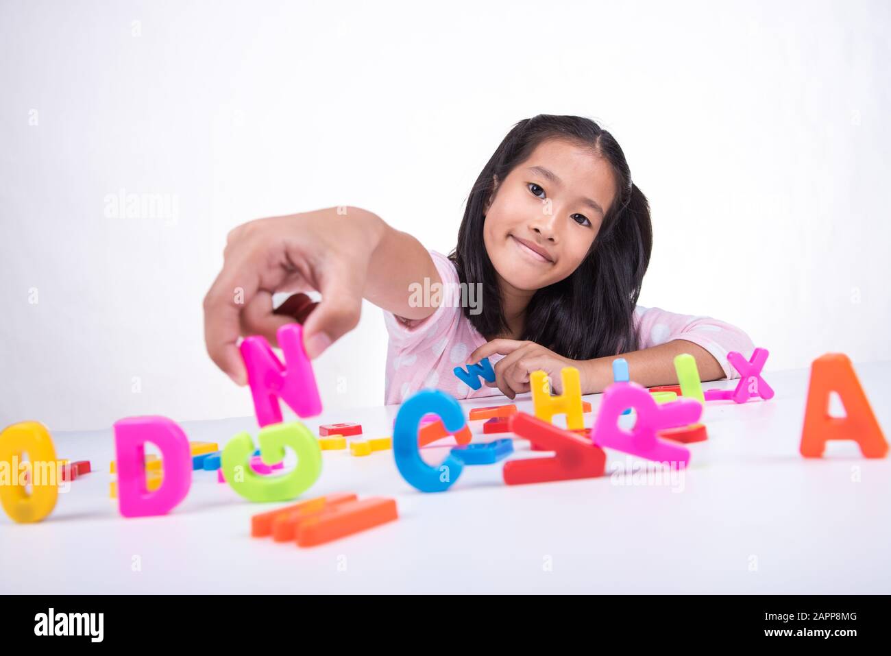 La petite fille asiatique apprend avec le modèle de jouet ABC Banque D'Images