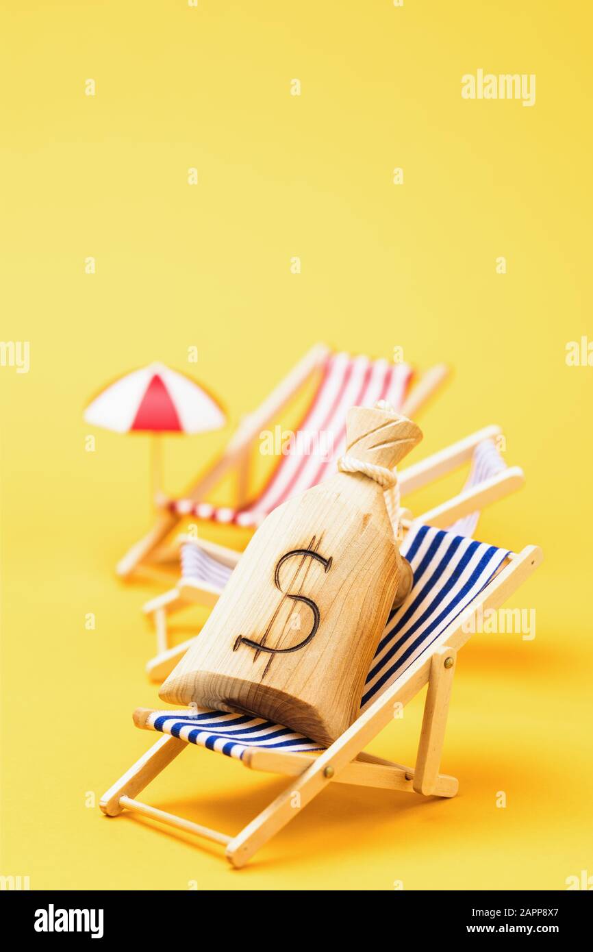 Sac en bois avec symbole dollar sur une chaise longue sur un fond jaune avec espace de copie. Concept sur le thème de l'épargne d'argent pour des vacances Banque D'Images