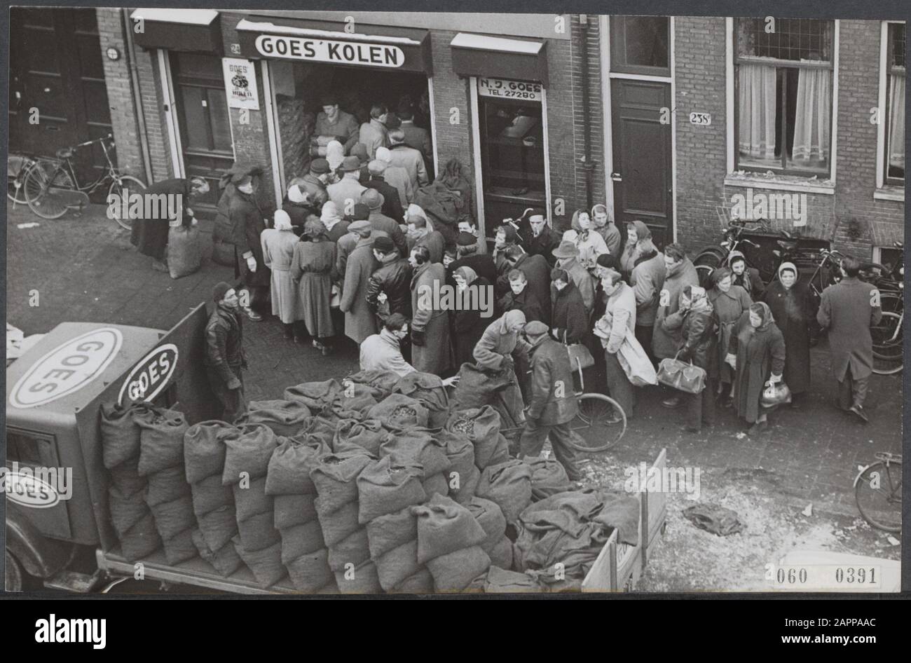 Pénurie de charbon au début de l'hiver. L'approvisionnement en charbon à Amsterdam est de plus en plus important. Des dizaines de personnes doivent maintenant faire la queue auprès de leur fournisseur de charbon pour obtenir quelques sacs de leur or noir Date: 24 février 1956 lieu: Amsterdam, Noord-Holland mots clés: Population, charbon, hivers Nom personnel: Goes kolen Banque D'Images