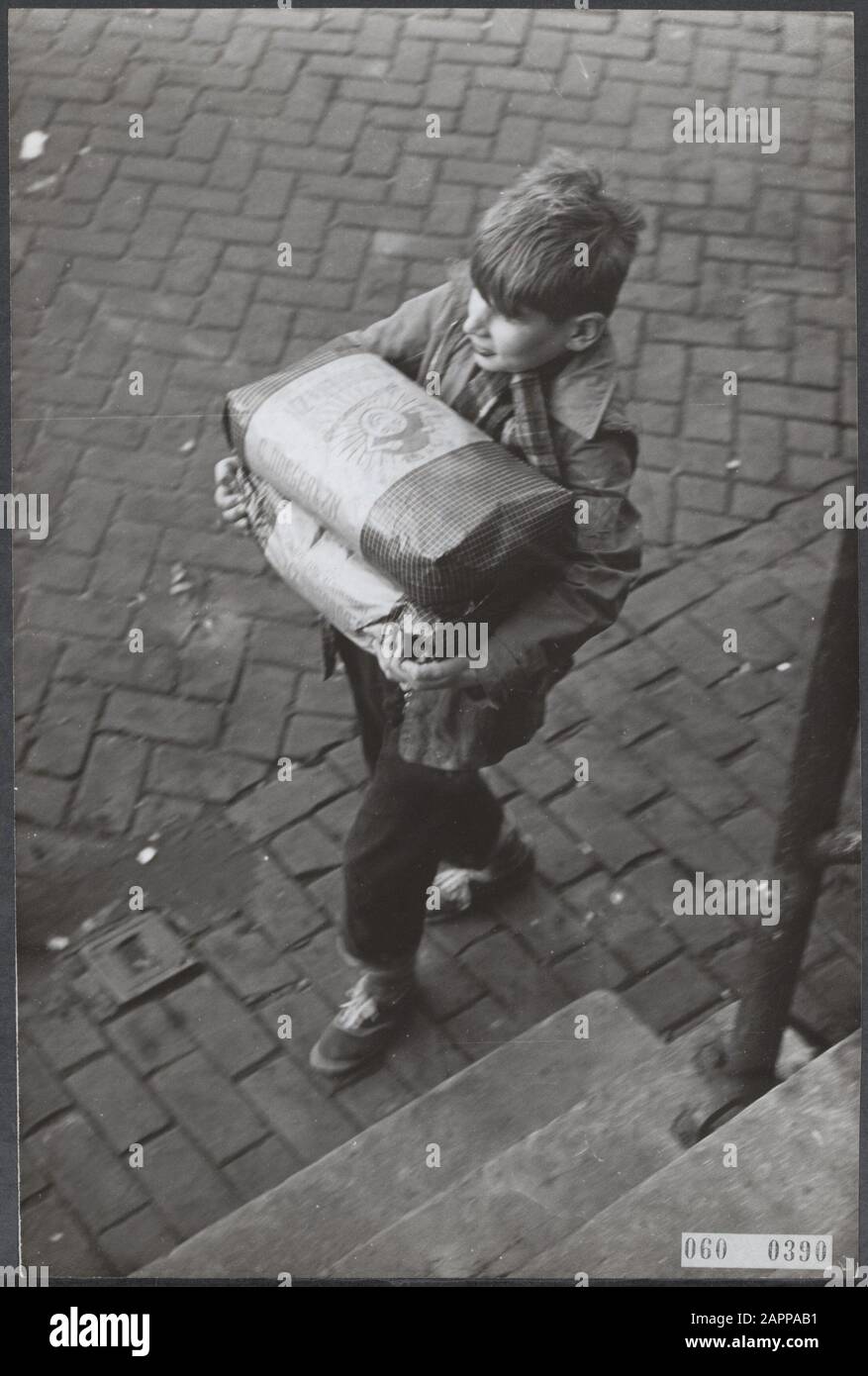 Pénurie de charbon au début de l'hiver. Lorsque vous devez acheter le charbon à une bourse médiocre, cela se produit dans des sacs en papier. Sur le chemin de la maison avec nouveau stock Date: 13 décembre 1955 lieu: Amsterdam, Noord-Holland mots clés: Population, charbon, hivers Banque D'Images