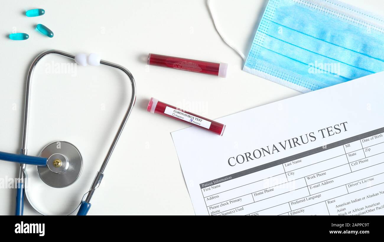 Concept de test sanguin du coronavirus. Table de laboratoire avec test de coronavirus sous forme médicale, masque respiratoire, tubes à essai avec sang, stéthoscope, pilules. 2019 Banque D'Images