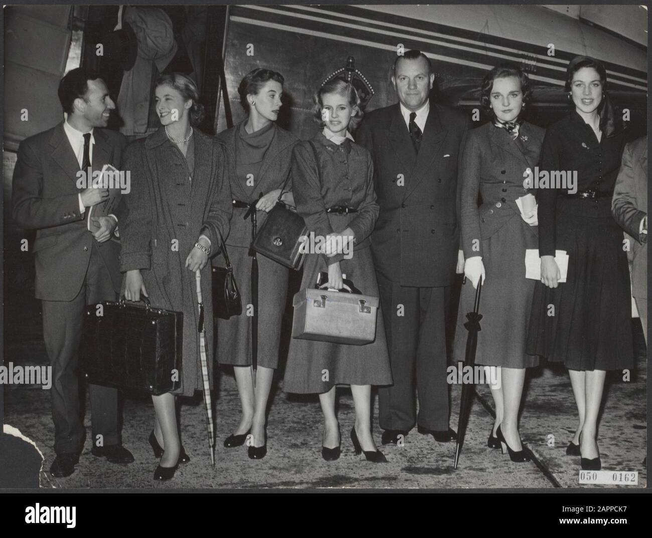 De Londres est arrivé à Schiphol, cinq mannequins anglais avec le couturier néerlandais Herbert Sidon. Vlnr. Herbert Sidon, Mary Williamson, Mlle Severen, Lady Sally Ann Vivian, M. Meyens, directrice de l'hôtel Victoria où se déroule le défilé de mode, Serene Sheffield et Margaret Ann du canne Date : 5 septembre 1952 Banque D'Images