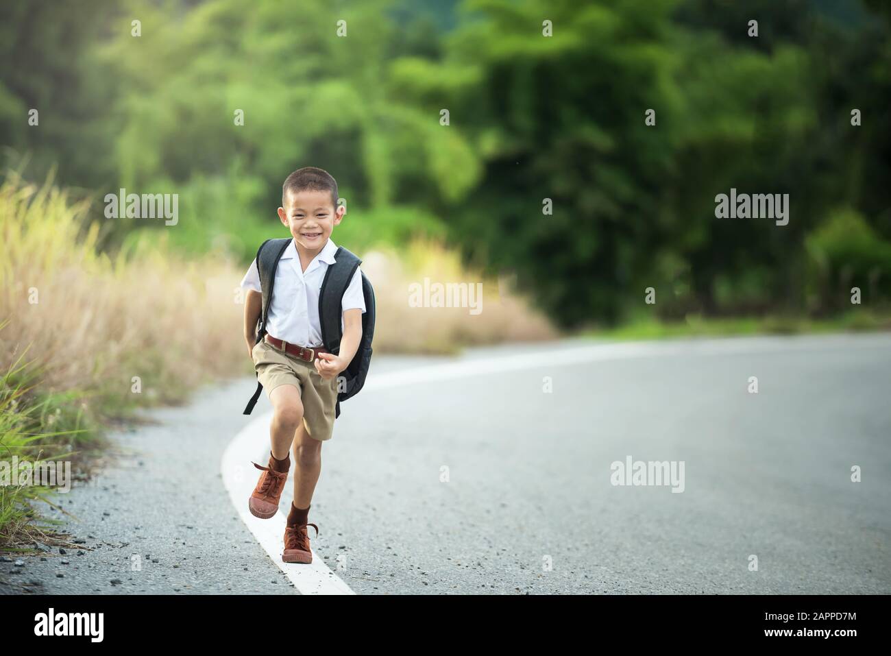 Un petit garçon asiatique heureux va à l'école Banque D'Images