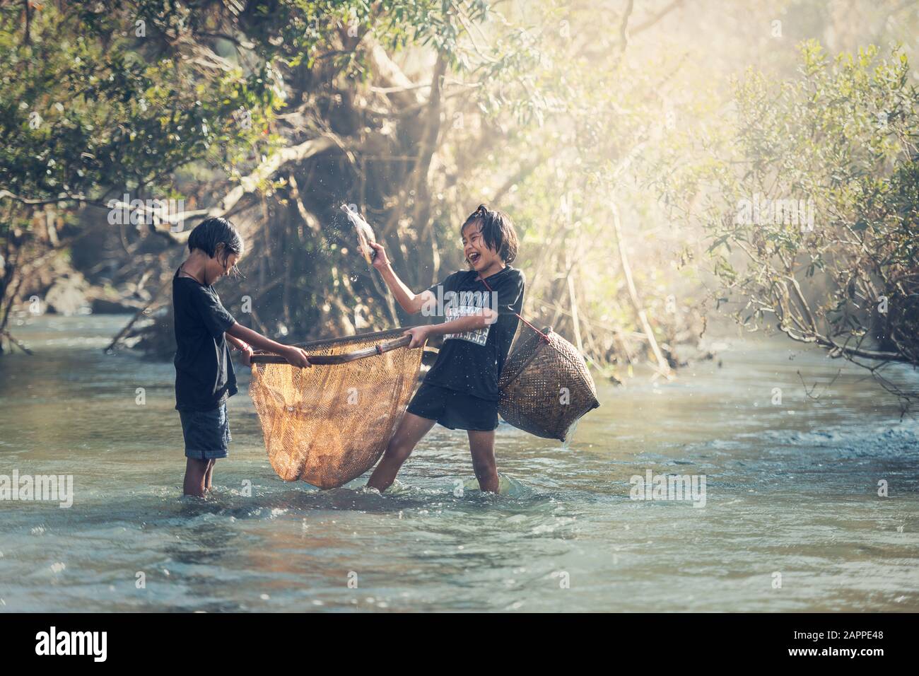 Les filles asiatiques pêchent au bord de la rivière Banque D'Images