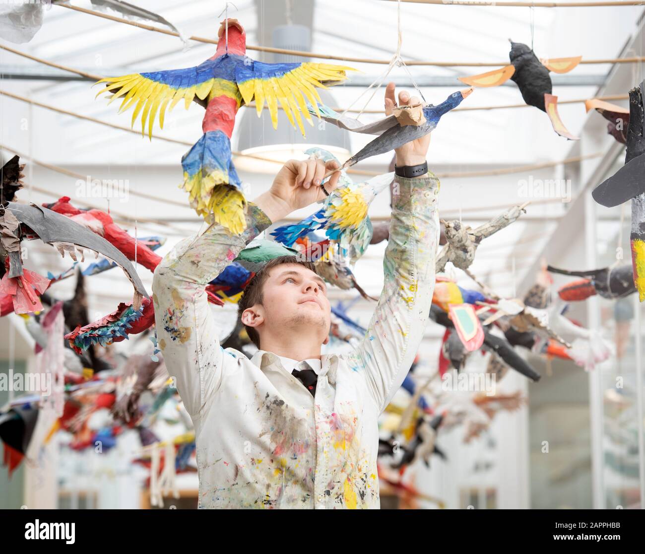 Un étudiant en art suspend les oiseaux en papier dans une école secondaire, au Royaume-Uni Banque D'Images