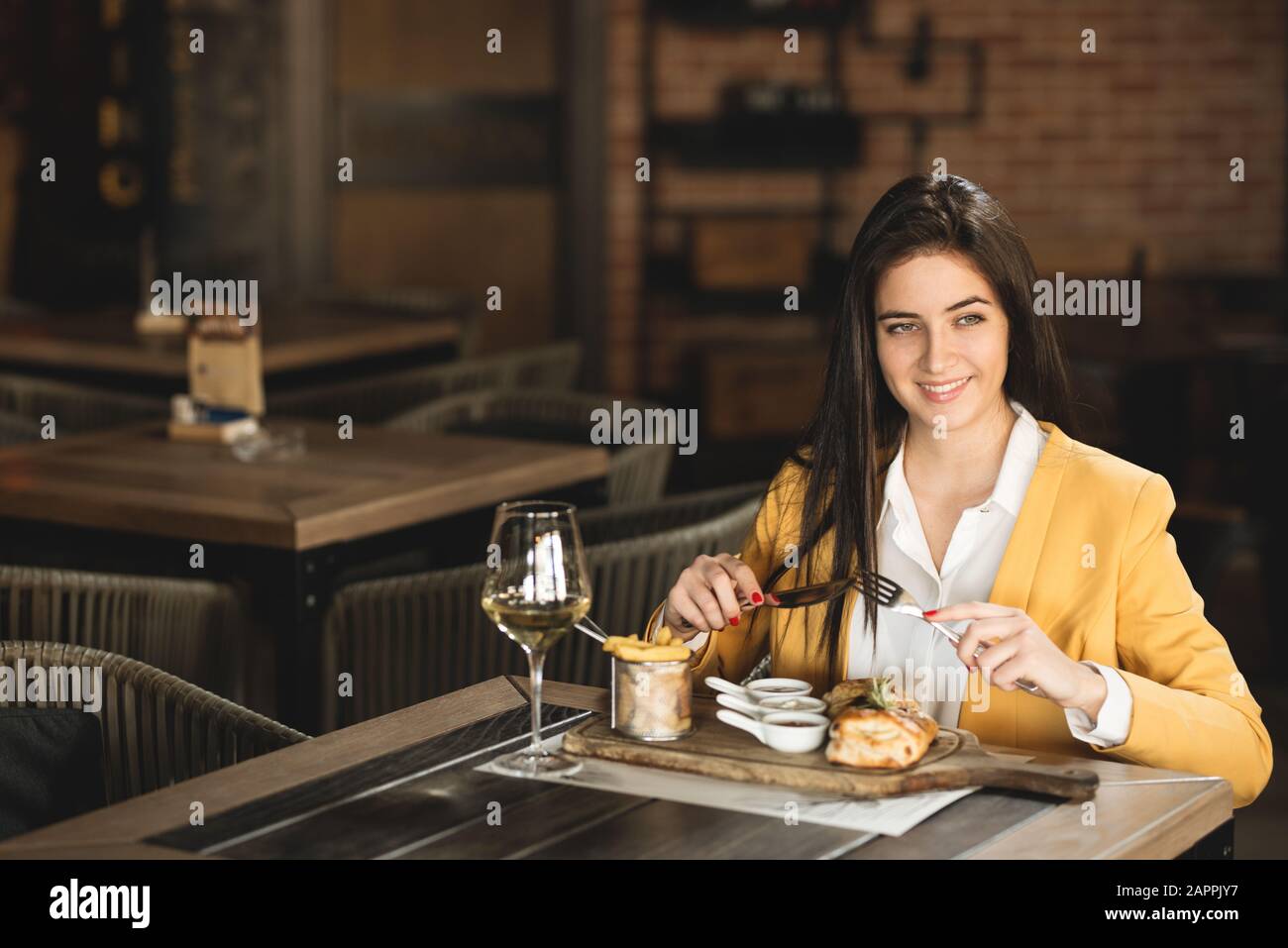 Femme d'affaires assise au restaurant et mange après le travail Banque D'Images