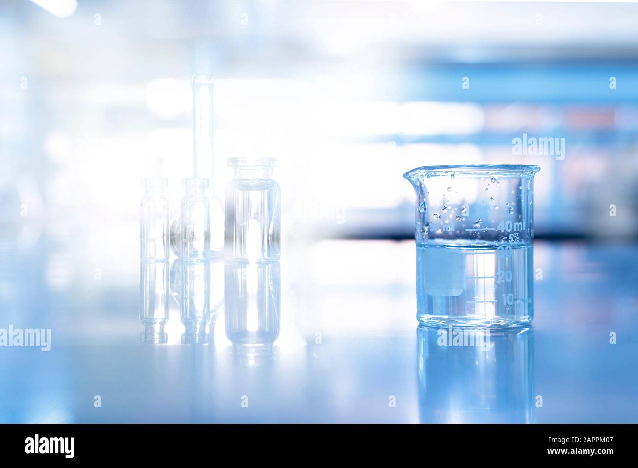 bécher en verre dans un fond de laboratoire de chimie scientifique bleu doux Banque D'Images