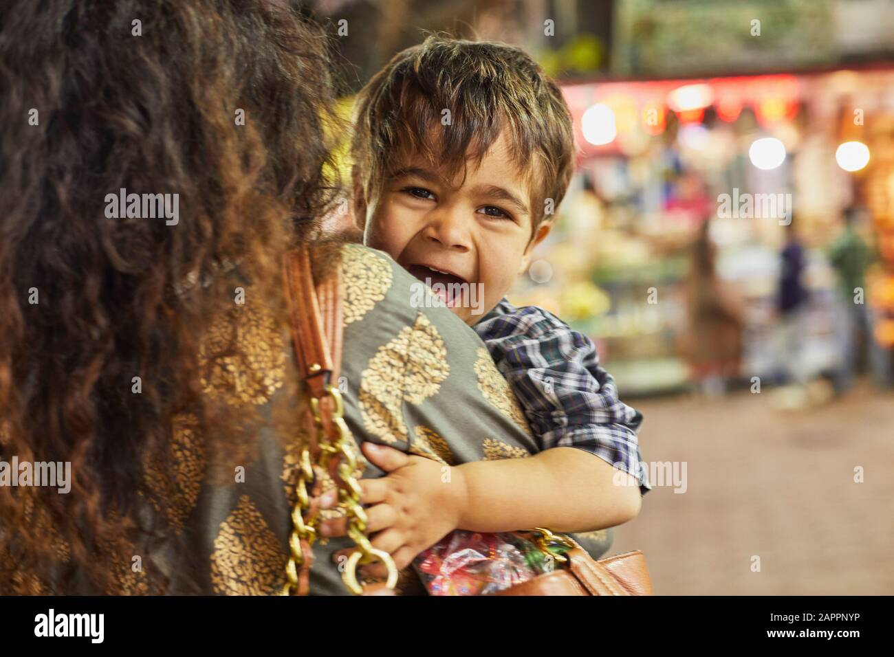 Mère transportant un petit garçon excité dans bazar Banque D'Images