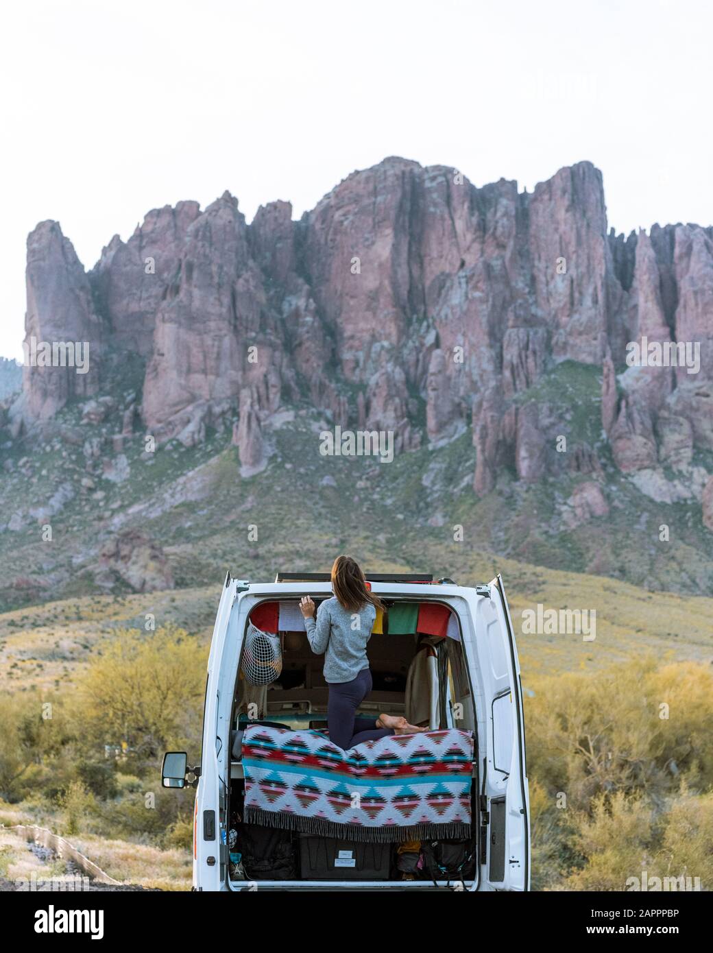 Femme en véhicule tout-terrain, montagnes Superstition en arrière-plan, Arizona, États-Unis Banque D'Images