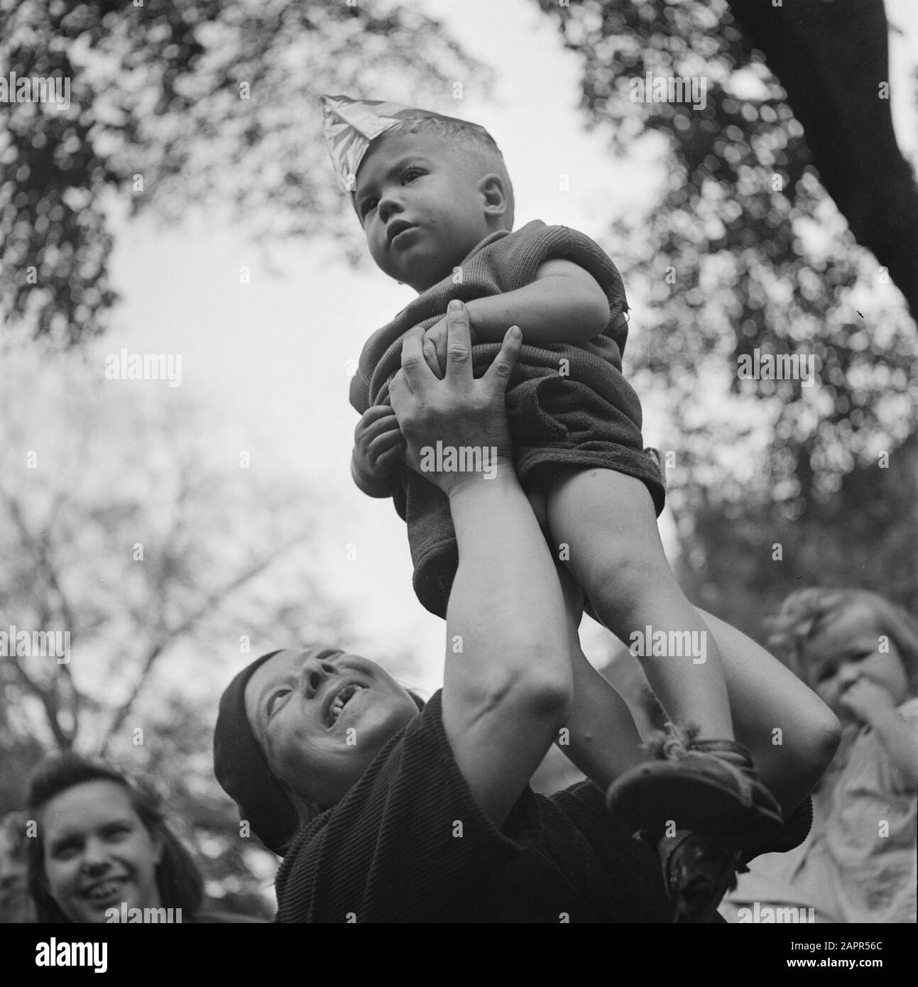Les divertissements populaires à Amsterdam. Rép. Des diverses festivités liées à la libération dans la capitale [UN tout-petit est élevé par une femme] Date: 28 juin 1945 lieu: Amsterdam, Noord-Holland mots clés: Festivals de libération, deuxième Guerre mondiale Banque D'Images
